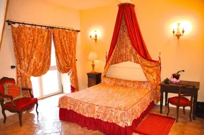 a bedroom with a red canopy bed in a room at Hôtel Château de Cavanac in Carcassonne