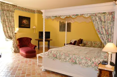 a bedroom with a bed and a living room at Hôtel Château de Cavanac in Carcassonne