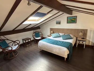 a bedroom with a bed in a room with wooden floors at Domaine de Hurlevent in Montgaillard-Lauragais