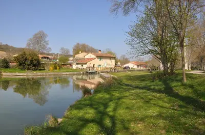 a body of water with a house in the background at Domaine de Hurlevent in Montgaillard-Lauragais