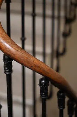 a wooden rail on a staircase with a fence in the background at Le Temps d'Eugène Centre historique in Narbonne