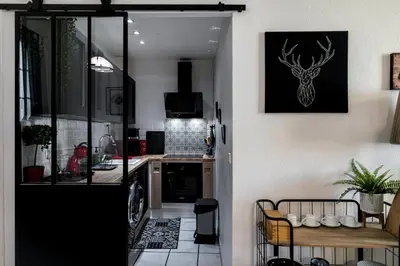 a kitchen with a door leading to a dining room at Le Temps d'Eugène Centre historique in Narbonne