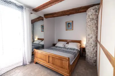 a bedroom with two beds and a stone wall at Studio du couvent des carmes in Narbonne