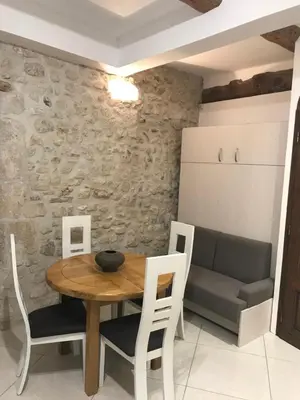 a dining room with a table and chairs and a couch at Studio du couvent des carmes in Narbonne