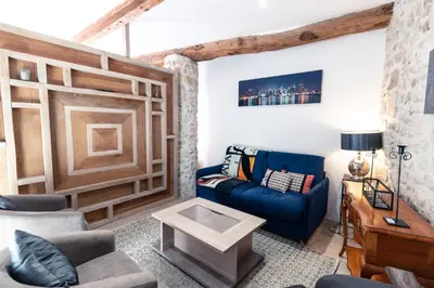 a living room with a blue couch and a table at Studio du couvent des carmes in Narbonne