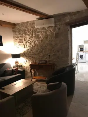 a living room with couches and a stone wall at Studio du couvent des carmes in Narbonne