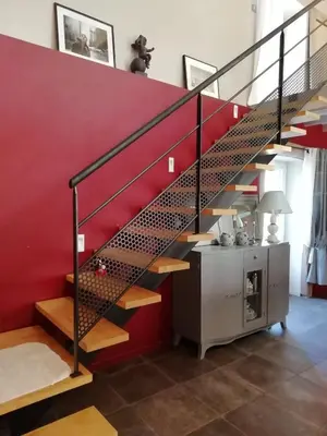 a staircase in a house with a red wall at Les Treillettes in Puylaurens