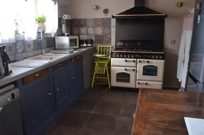 a kitchen with blue cabinets and a white stove top oven at Les Treillettes in Puylaurens
