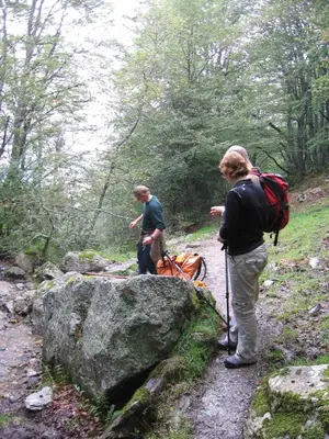 two people standing on a trail near a rock at Chateau de Camurac in Camurac