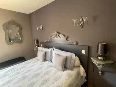 a bedroom with a bed with white sheets and pillows at Pelletier du Claux in Carcassonne