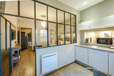 a kitchen with white cabinets and glass windows at Pelletier du Claux in Carcassonne