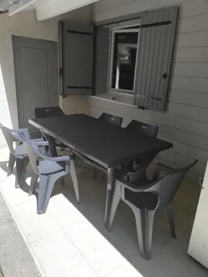 a black table and chairs on a patio at La Truite in Saint-Amans-Valtoret