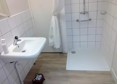 a white bathroom with a sink and a shower at La Truite in Saint-Amans-Valtoret