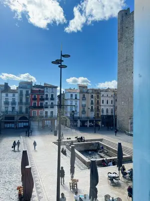 a view of a city square with buildings and people at Domus Via Domitia in Narbonne