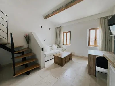 a living room with a white couch and a staircase at Domus Via Domitia in Narbonne
