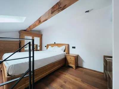 a bedroom with a bed and a wooden floor at Domus Via Domitia in Narbonne