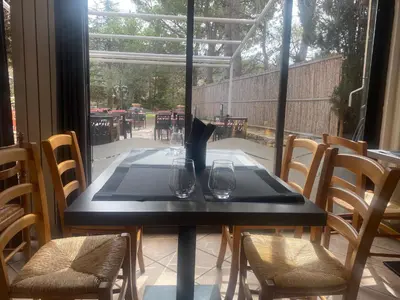 a black table with two wine glasses on a patio at Auberge la Table du Curé in Cucugnan