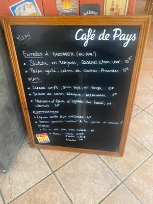 a chalkboard sign for a cafe de pay signs at Auberge la Table du Curé in Cucugnan