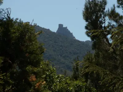 a mountain in the distance with trees in the foreground at Auberge la Table du Curé in Cucugnan