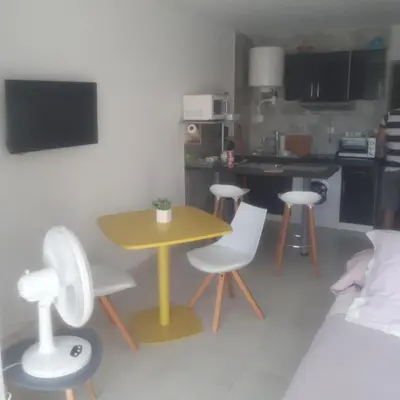a small kitchen with a yellow table and chairs at Studio avec jardinet clim parking in Gruissan