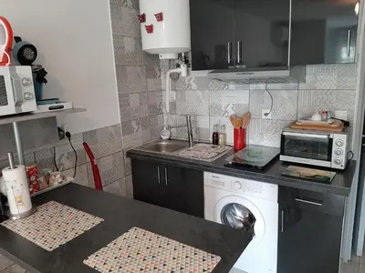 a kitchen with a sink and a washing machine at Studio avec jardinet clim parking in Gruissan