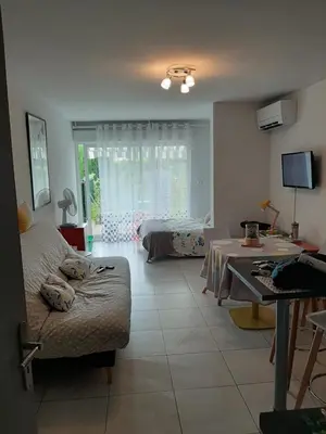 a living room with a couch and a table at Studio avec jardinet clim parking in Gruissan