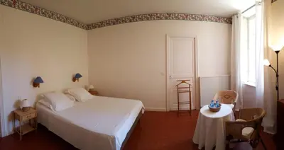 a bedroom with a white bed and a table at Château Haut Gléon in Villesèque-des-Corbières