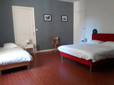 a bedroom with two beds and a red floor at Château Haut Gléon in Villesèque-des-Corbières