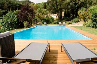 a swimming pool with two lounge chairs next to it at Château Haut Gléon in Villesèque-des-Corbières