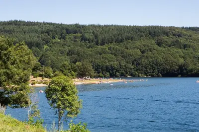 a group of people on a beach in a lake at Logis hôtel restaurant Auberge de l'Espinouse in Fraisse-sur-Agout
