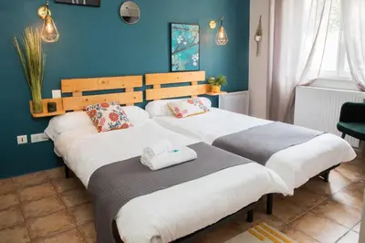 two beds in a room with blue walls at Logis hôtel restaurant Auberge de l'Espinouse in Fraisse-sur-Agout