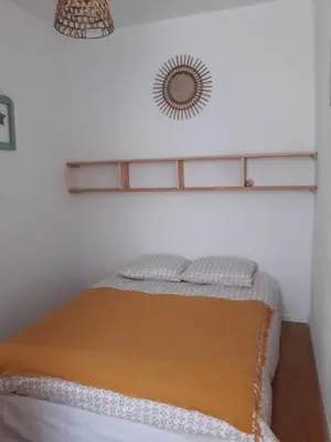 a bed in a room with a mirror on the wall at La Coulée Douce - Chez Antoine in Castelnaudary