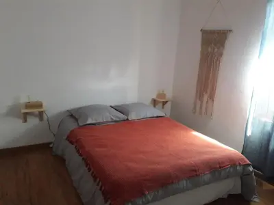 a bedroom with a bed with a red blanket at La Coulée Douce - Chez Antoine in Castelnaudary