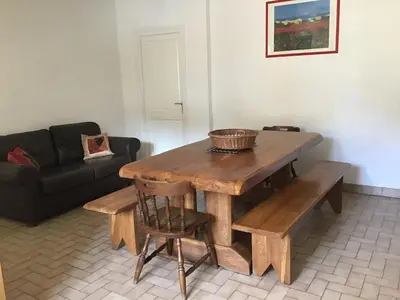 a living room with a wooden table and a couch at Maison de la Fontaine in Embres-et-Castelmaure
