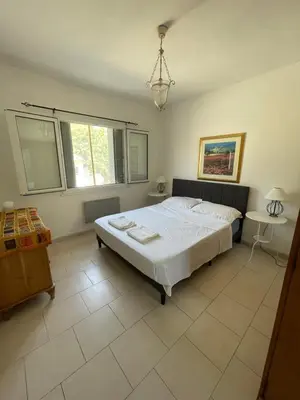 a bedroom with a large white bed in a room at Maison de la Fontaine in Embres-et-Castelmaure