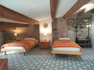 a bedroom with two beds in a room at Maison de caractère face à l abbaye de lagrasse in Lagrasse