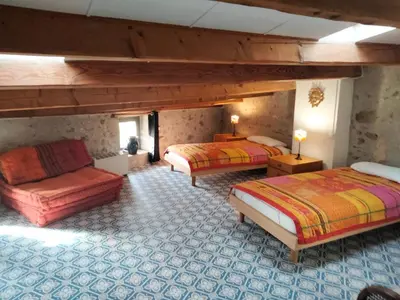a large room with two beds and a couch at Maison de caractère face à l abbaye de lagrasse in Lagrasse