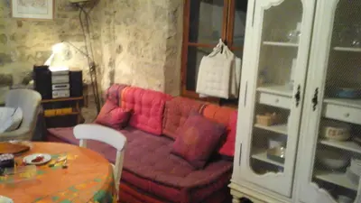 a living room with a red couch and a table at Maison de caractère face à l abbaye de lagrasse in Lagrasse