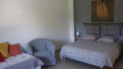 a bedroom with a bed and a chair next to a bed at La maison de l'écluse in Trèbes