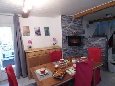 a dining room with a table and a fireplace at L'Ostalet in Prugnanes