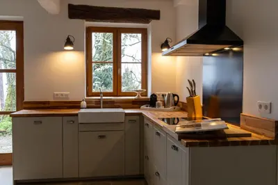 a kitchen with white cabinets and a sink and a window at Domaine de la Bade in Raissac-sur-Lampy