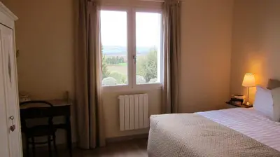 a bedroom with a bed and a window and a desk at Domaine de la Bade in Raissac-sur-Lampy