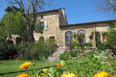 a stone house with a garden in front of it at Domaine de la Bade in Raissac-sur-Lampy