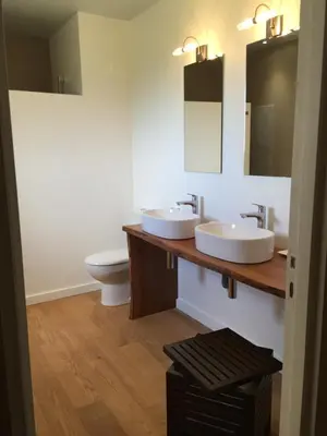 a bathroom with two sinks and a toilet at Chambres Ambroisie in Gueytes-et-Labastide