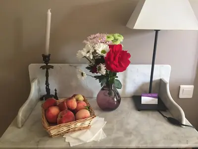 a table with a basket of apples and a vase with flowers at Chambres Ambroisie in Gueytes-et-Labastide