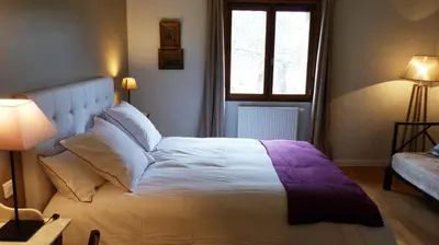a bedroom with a large white bed and a window at Chambres Ambroisie in Gueytes-et-Labastide