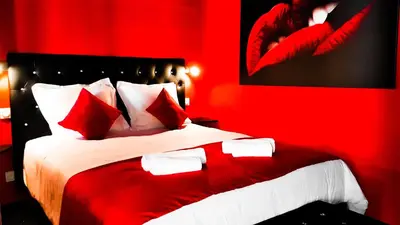 a room with a couch and a bed and a bathroom at Suite Romantique in Narbonne