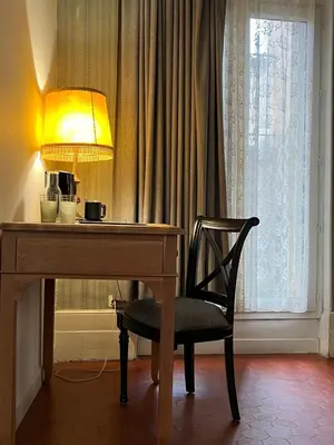 a desk with a lamp and a chair next to a window at Les Chambres des Barques in Narbonne