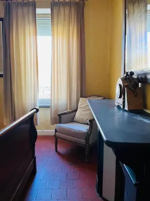 a room with a bench and a chair and a window at Les Chambres des Barques in Narbonne