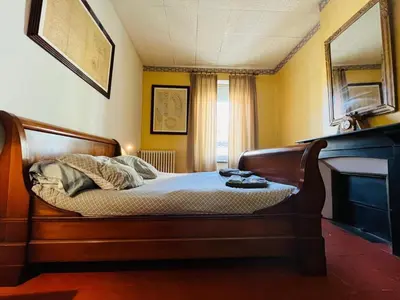 a bedroom with a wooden bed in a room at Les Chambres des Barques in Narbonne